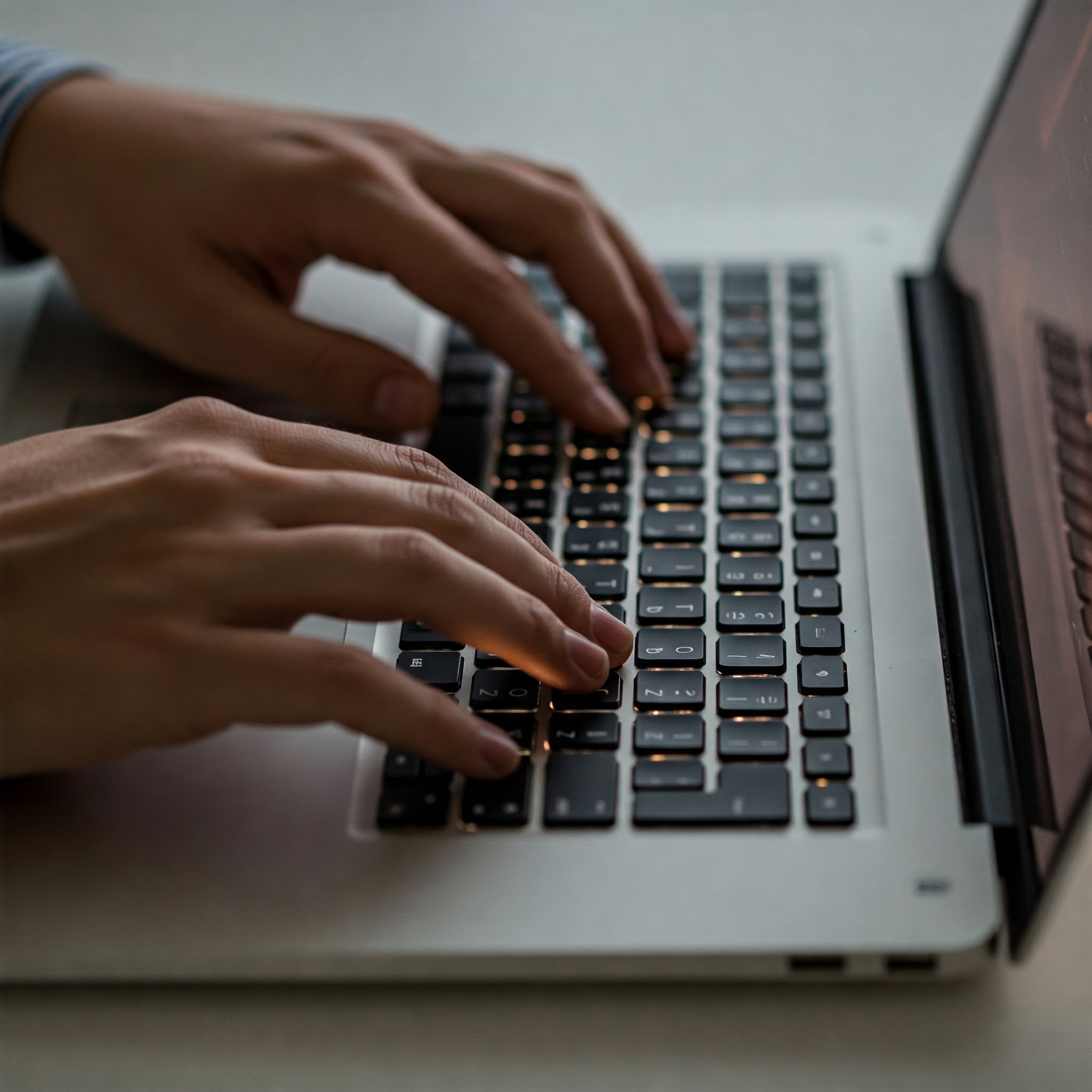 photo of Hands Typing on Laptop Keyboard